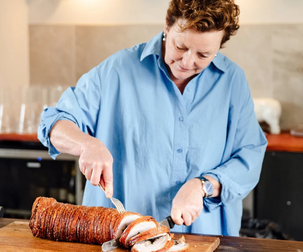 Kim Currie carves the crispy porchetta for lunch.