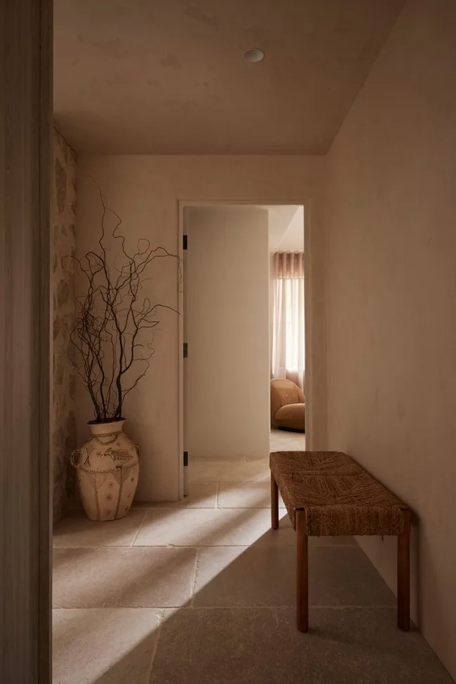 A hallway with a rattan bench