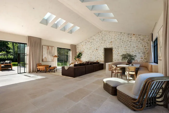 An open-plan living area with a stone wall and skylights
