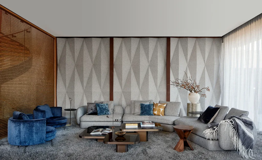 A lounge space with grey shag carpet and grey sofas