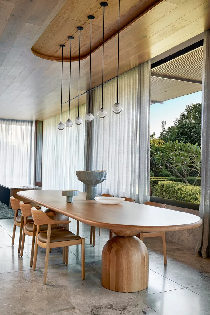 A curved dining table with garden views