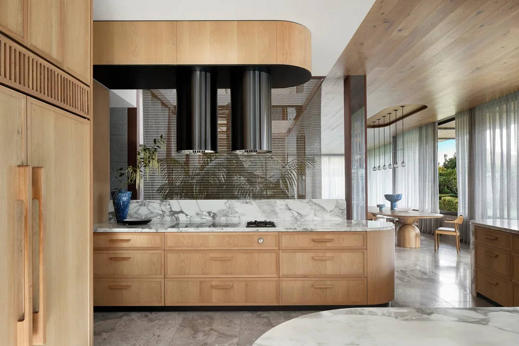 A marble and timber kitchen with curved cabinetry