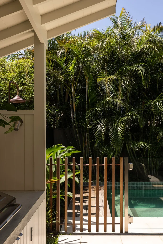 A tropical-style garden with a mosaic-tiled pool and palm trees