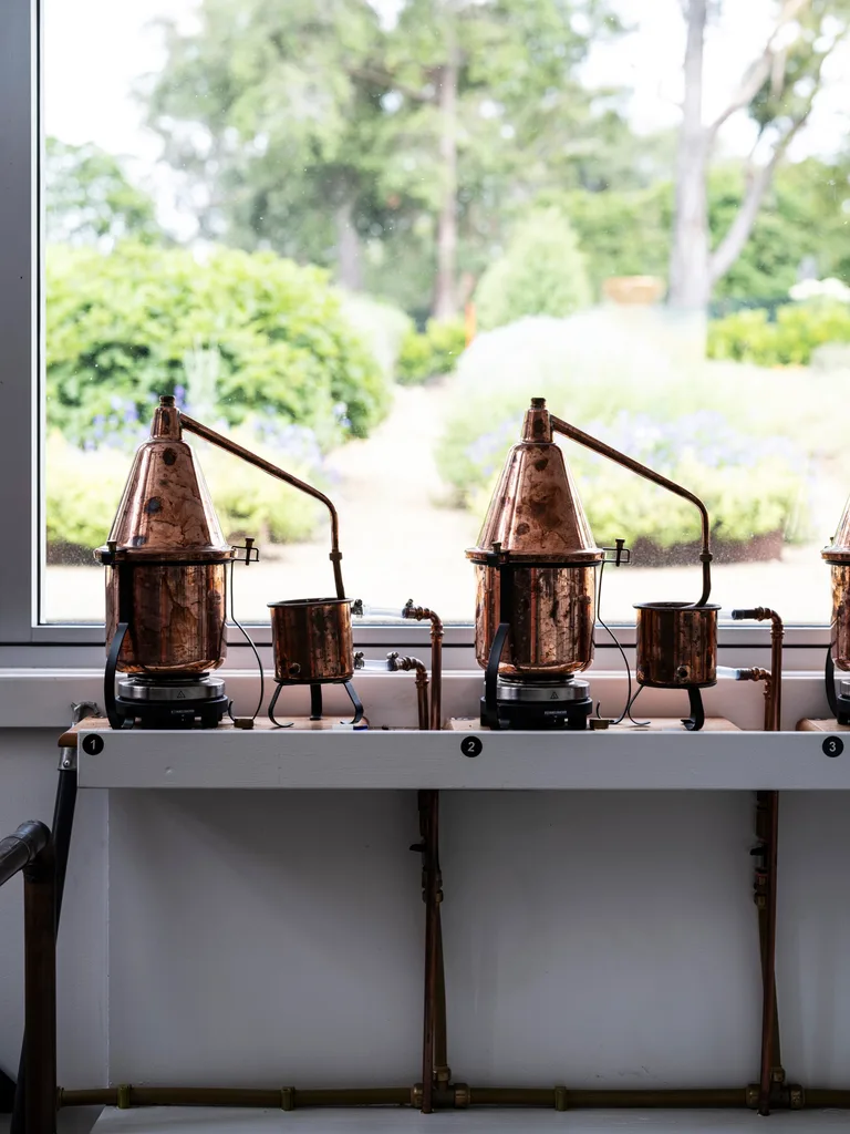 Brass stills on bench beside window looking out to garden