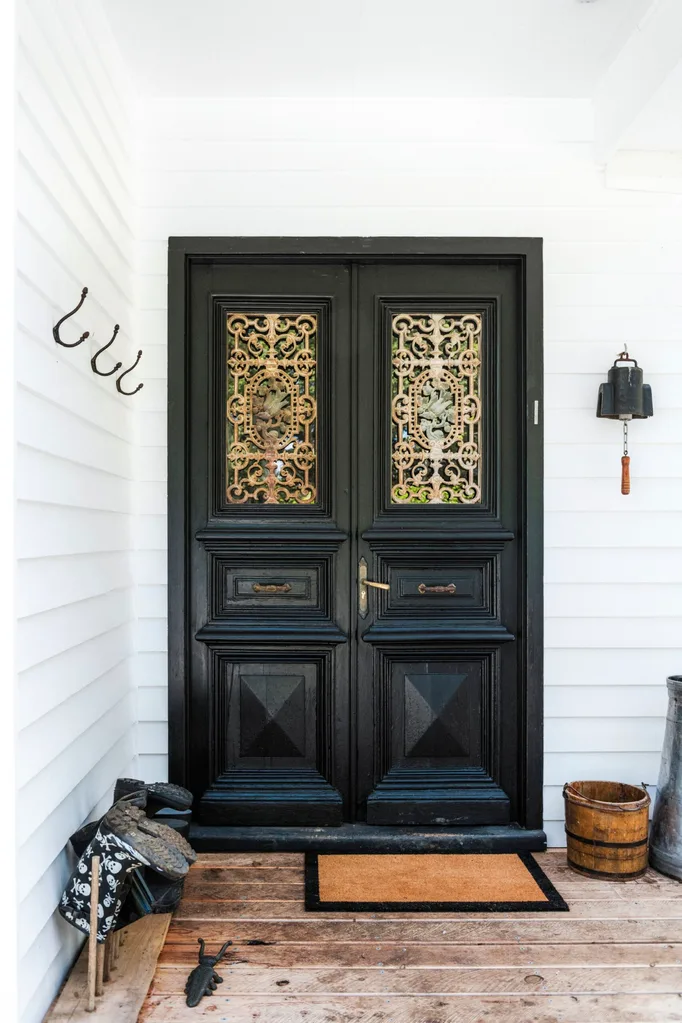 Black-painted double front door with wrought-iron screens in a Grand Ridge House tour