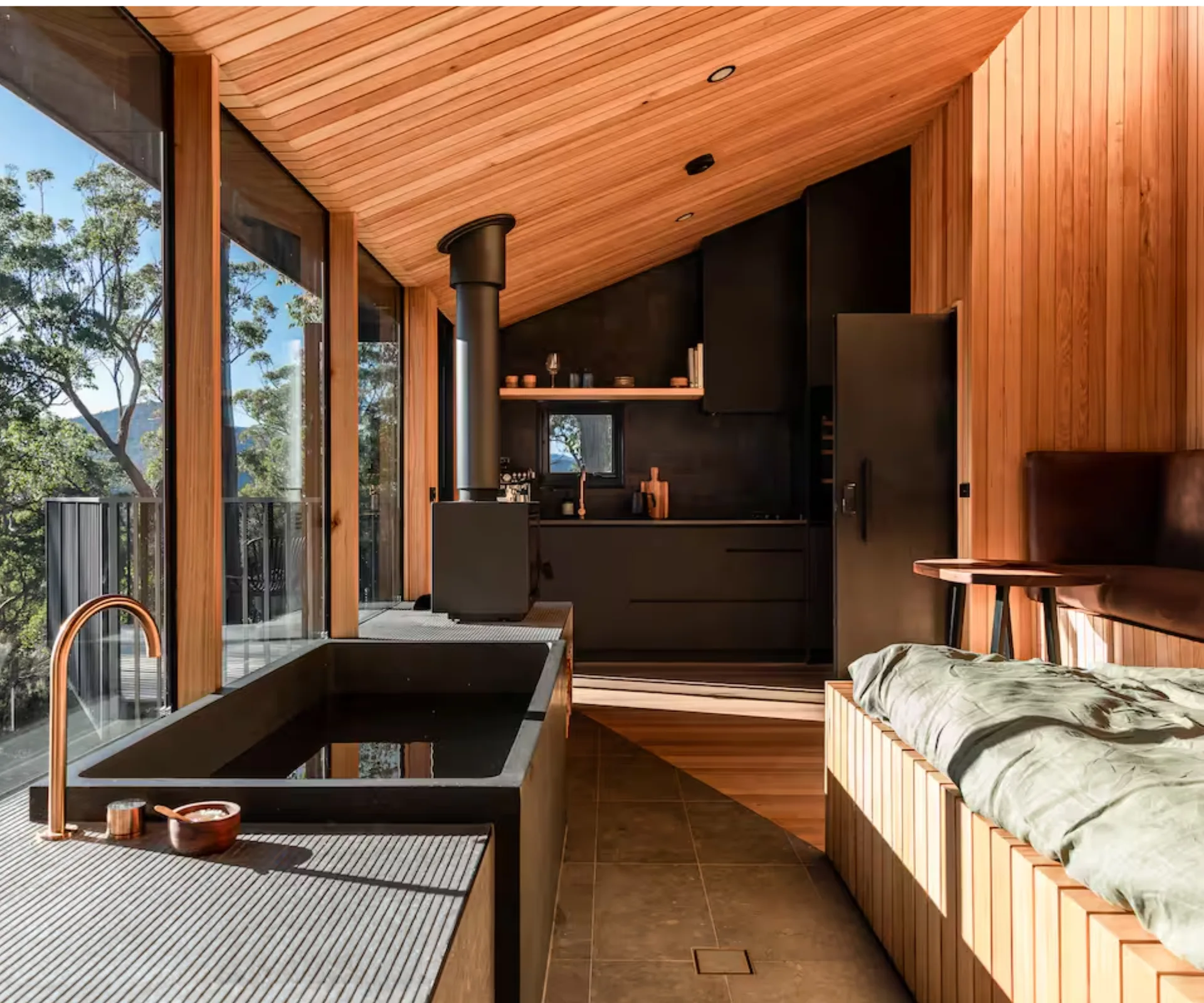 A cosy timber cabin with a bath and treetop views