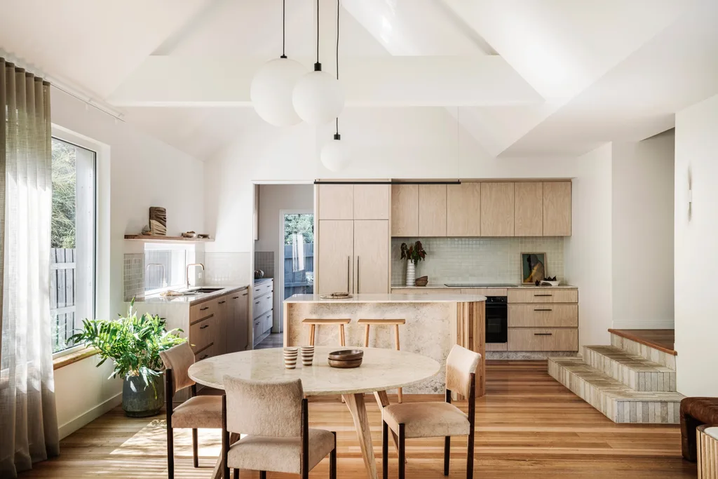 An open-plan kitchen and dining area with a pitched roof and pendant lighting