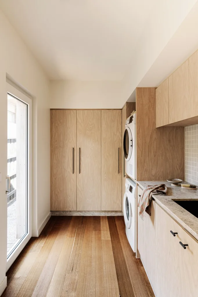 A laundry with timber flooring and cabinetry
