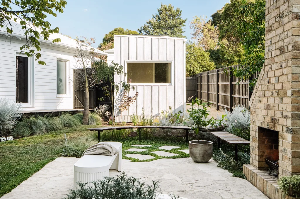 An outdoor fireplace with a curved bench and stepping stones