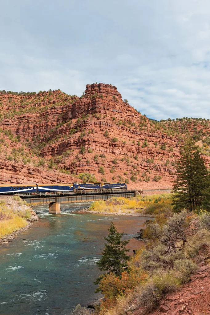 Train going along bridge over river with mountain behind in Travel Canada Rocky Mountains