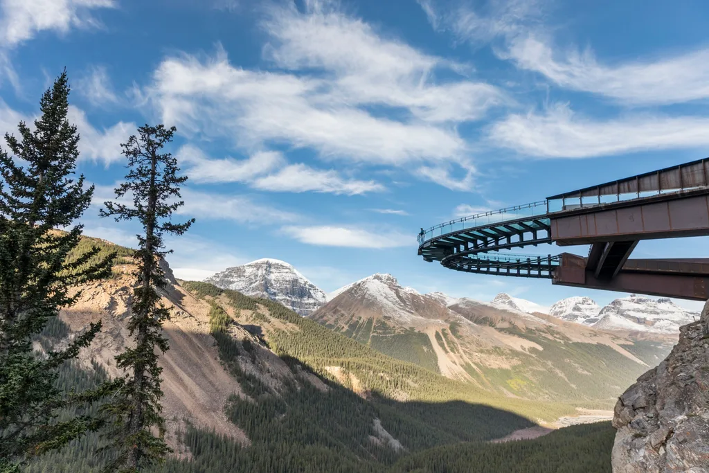 Curved walkway jutting out over a valley with mountains behind