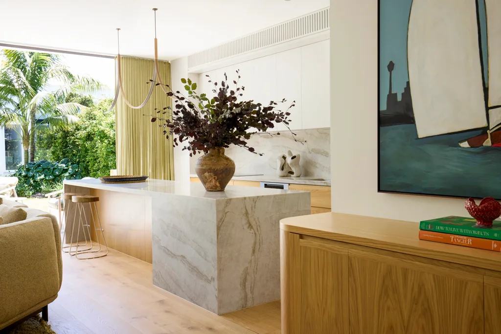 An open plan kitchen with timber cabinetry and stone benchtops