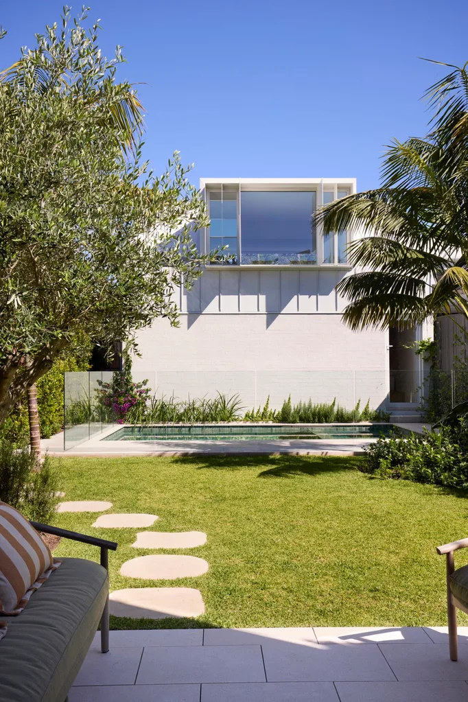 A garden with a swimming pool and patch of grass