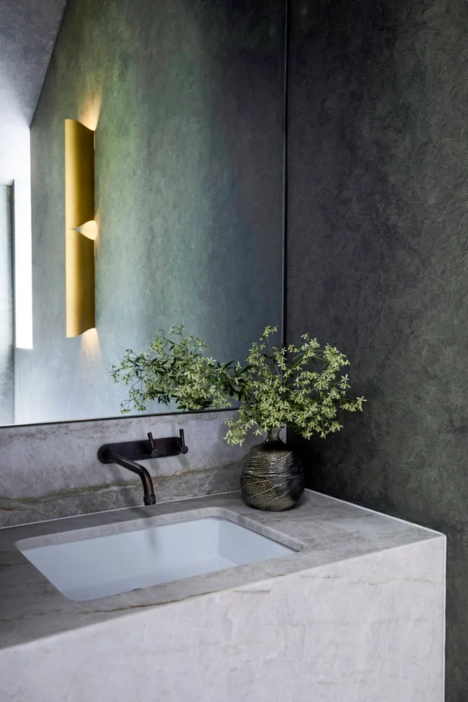 A moody powder room with dark green-grey walls