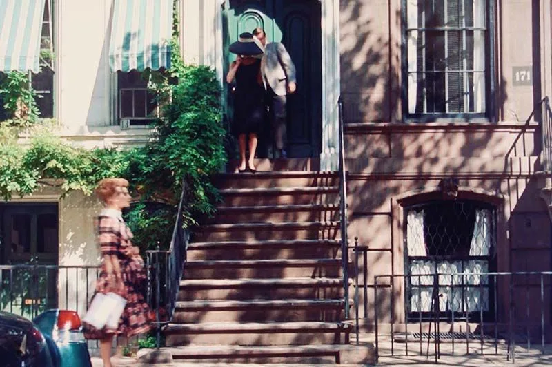 A still from the film 'Breakfast at Tiffany's' depicting characters Holly Golightly and Paul Varjak leaving a New York brownstone