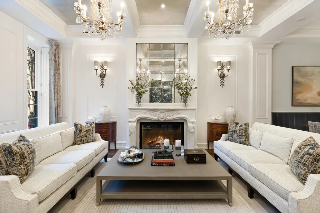 A luxurious sitting room with chandeliers and a stone fireplace