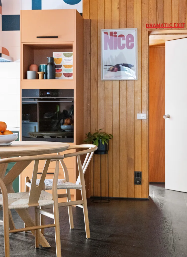 A mid-century style dining and kitchen area with timber panelling