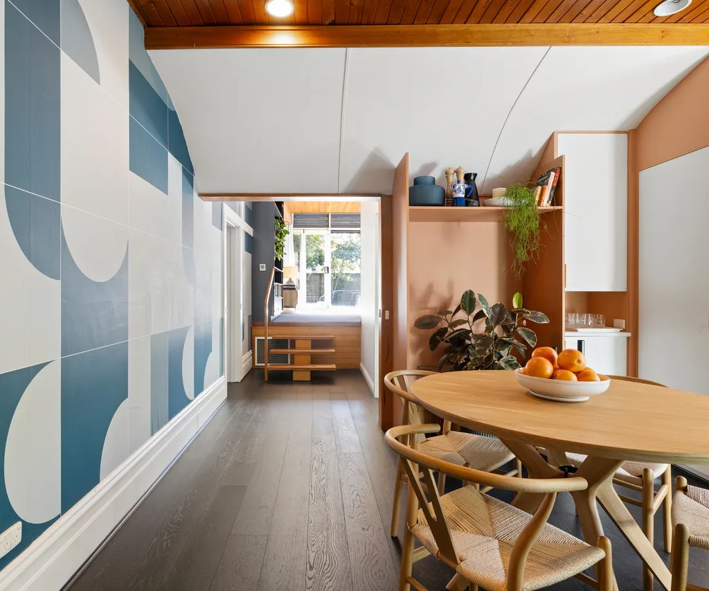 An open-plan kitchen and dining with bold blue wallpaper