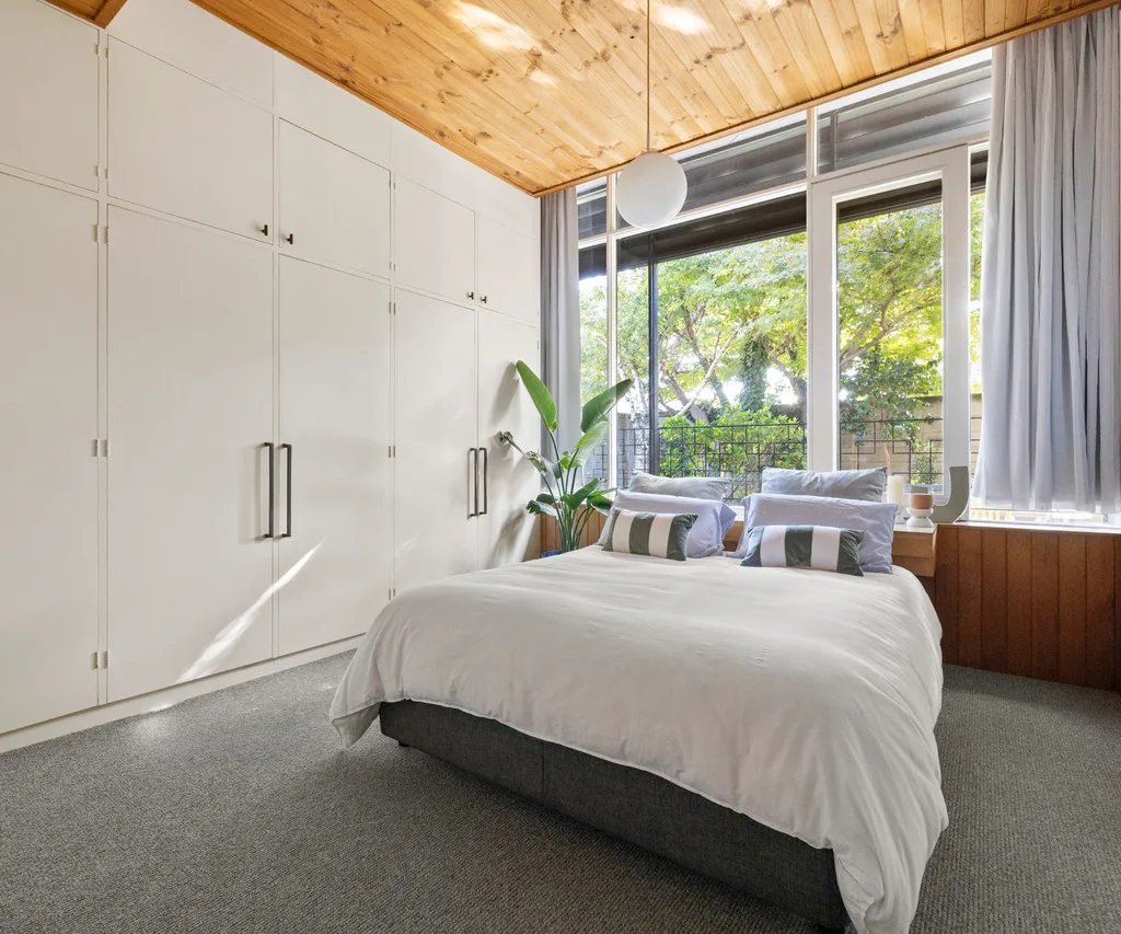 A spacious bedroom with timber panelled ceilings