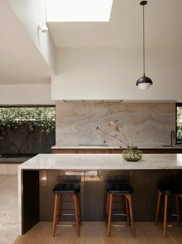 A kitchen with a large island and benchtops clad in Dolce Vita quartzite.
