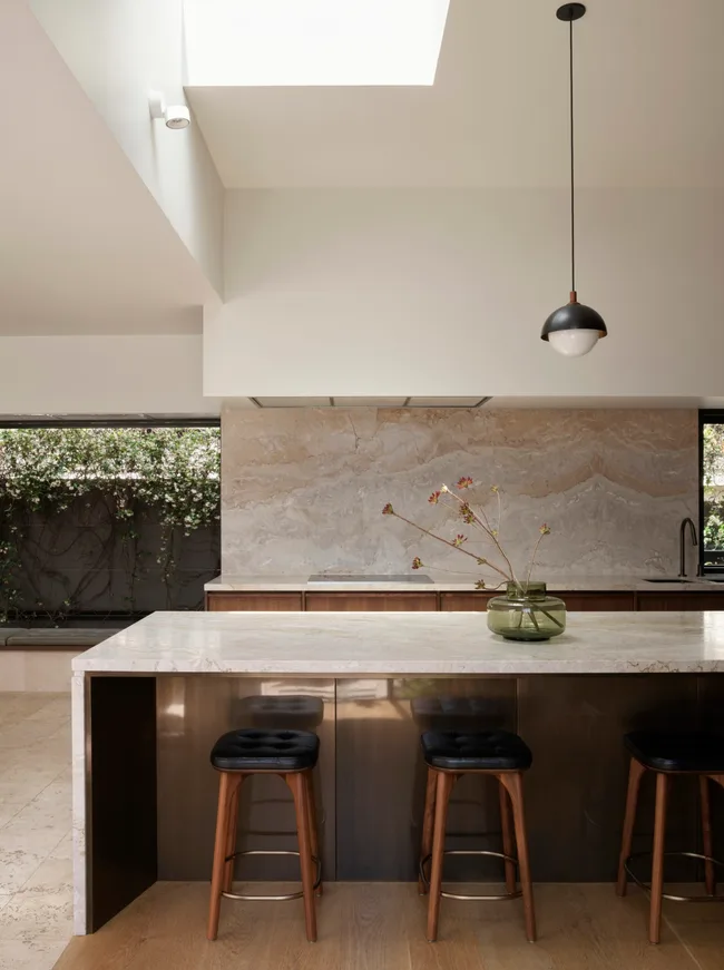 A kitchen with a large island and benchtops clad in Dolce Vita quartzite.