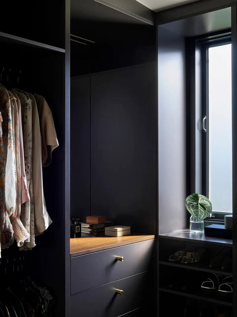 A walk-in wardrobe with Polytec joinery in Graphite and a benchtop in American walnut veneer.