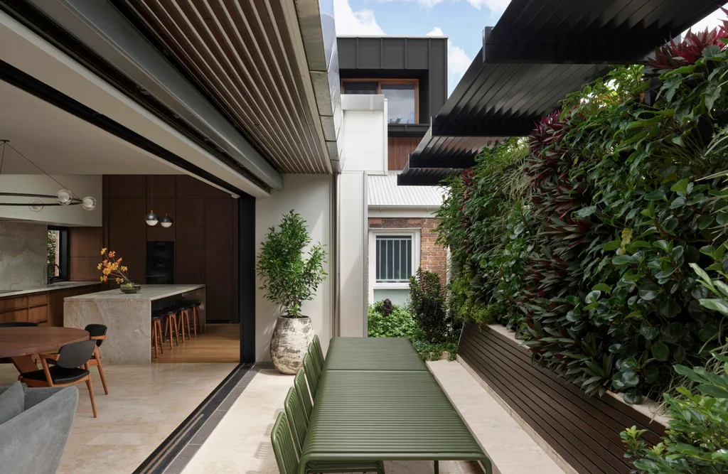 An open-plan courtyard in an inner Brisbane home with a lush feature wall.