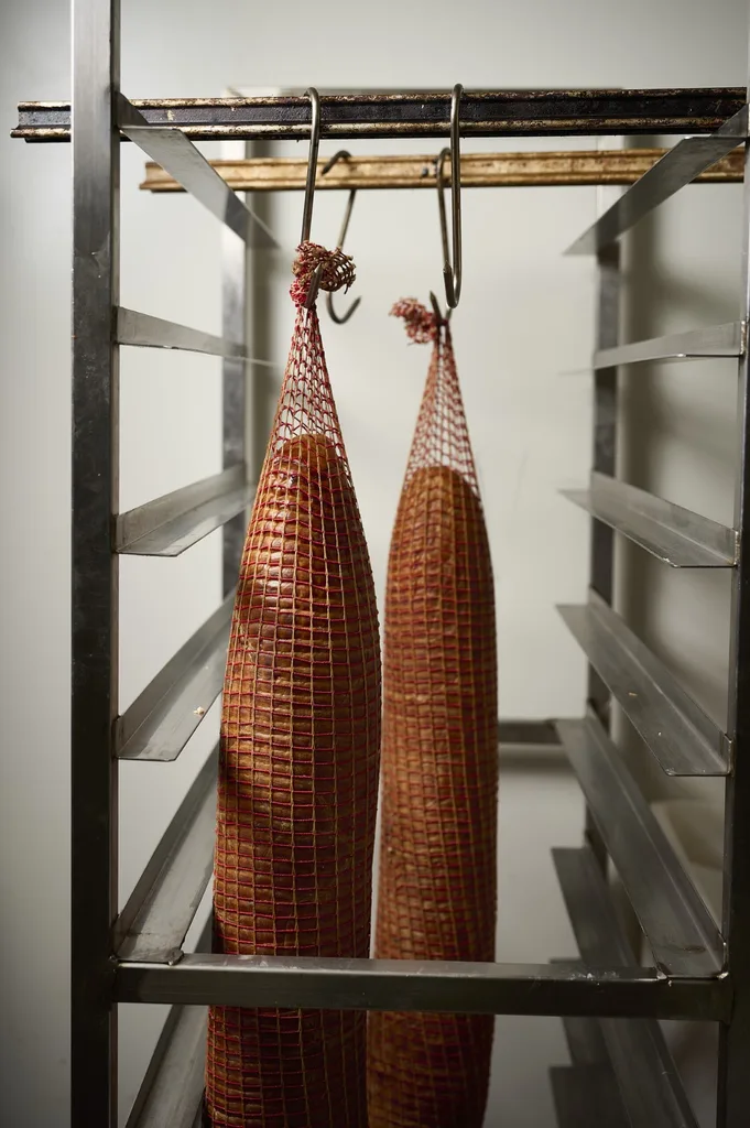 Two sausages hanging in netting