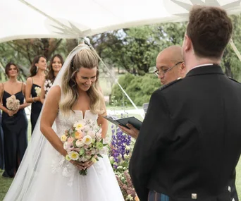 Bride, Sally getting married to groom, Andrew beneath a tent in the country