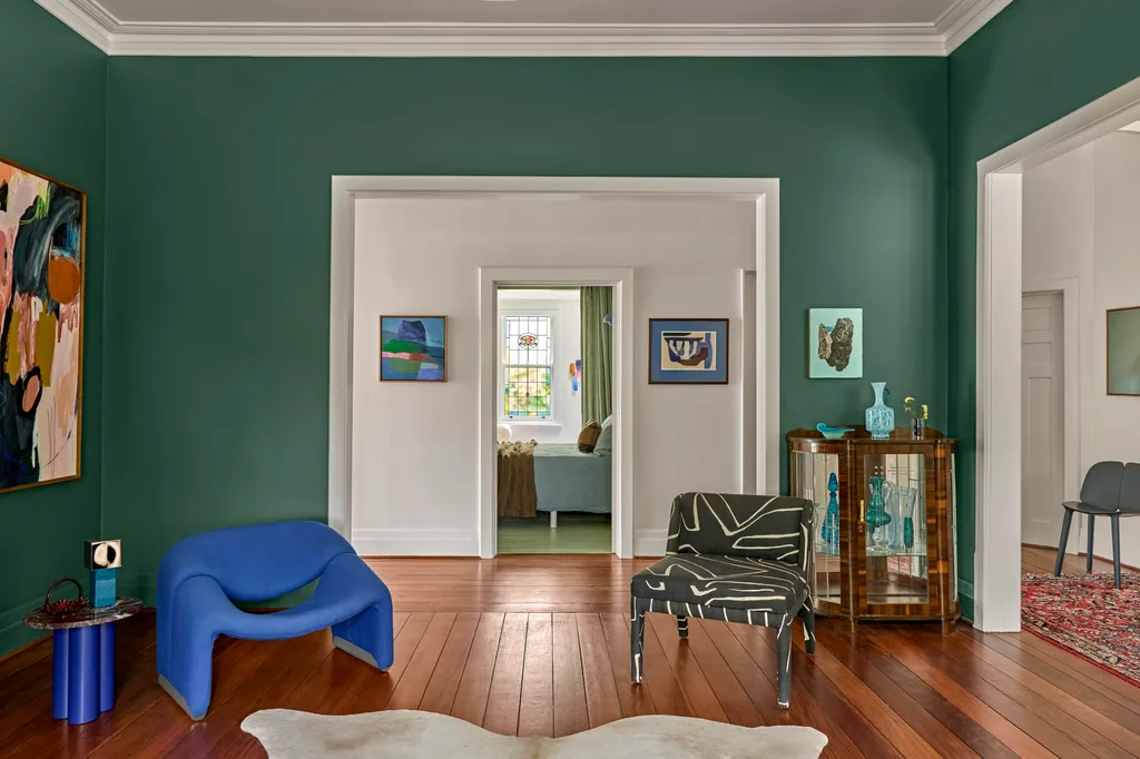 A green sitting room with statement armchairs