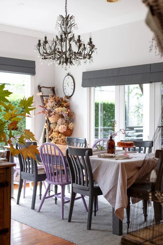 A cosy dining room with timber dining chairs and a chandelier