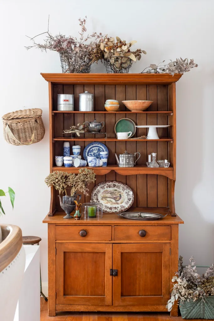 A timber shelving unit with old crockery