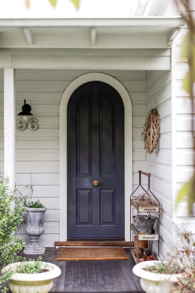 A curved front door of a weatherboard home