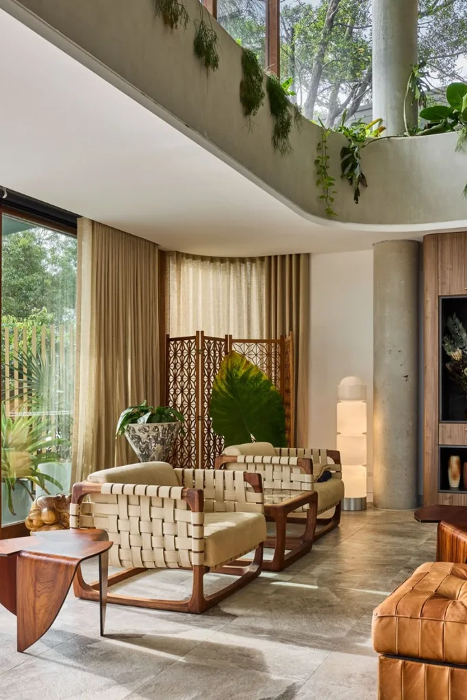 Open plan living room with two arm chairs and sheer wrap around curtains