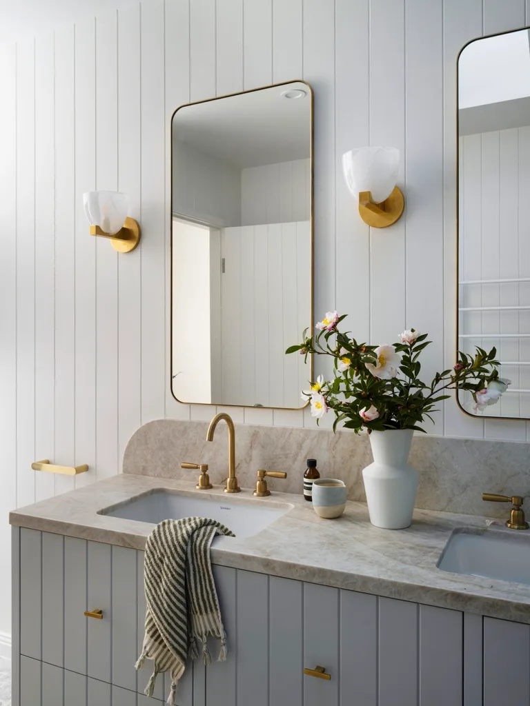 A double vanity with marble bench tops and curved mirrors