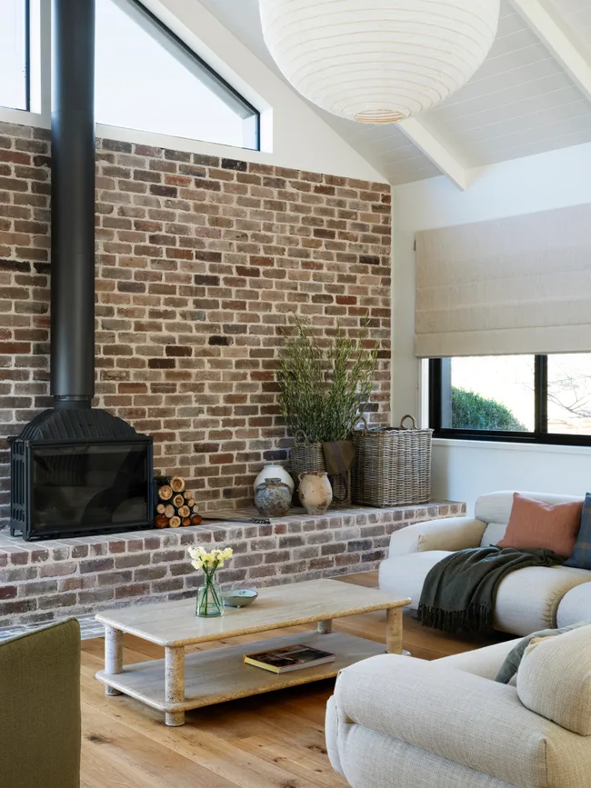 A living area with a brick feature wall and woodfire heater