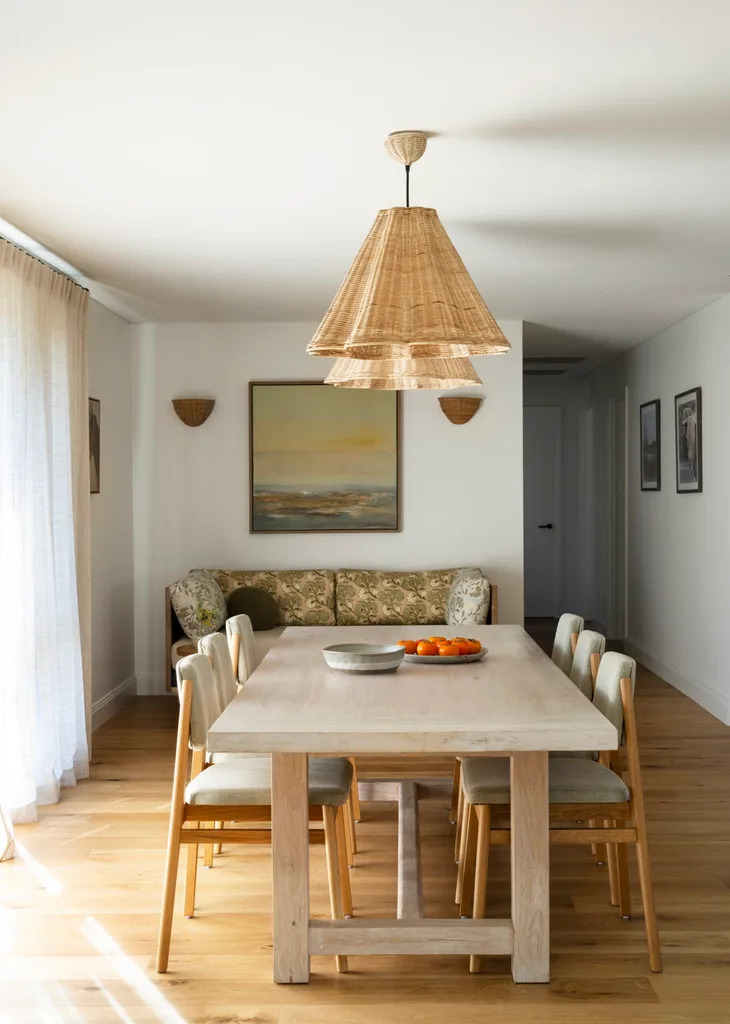A light timber dining table with rattan pendant lights