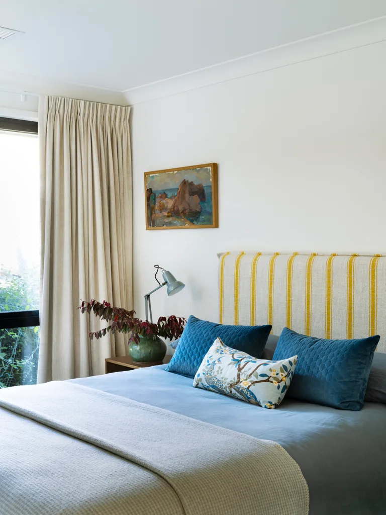 A bedroom with blue bedding and a striped