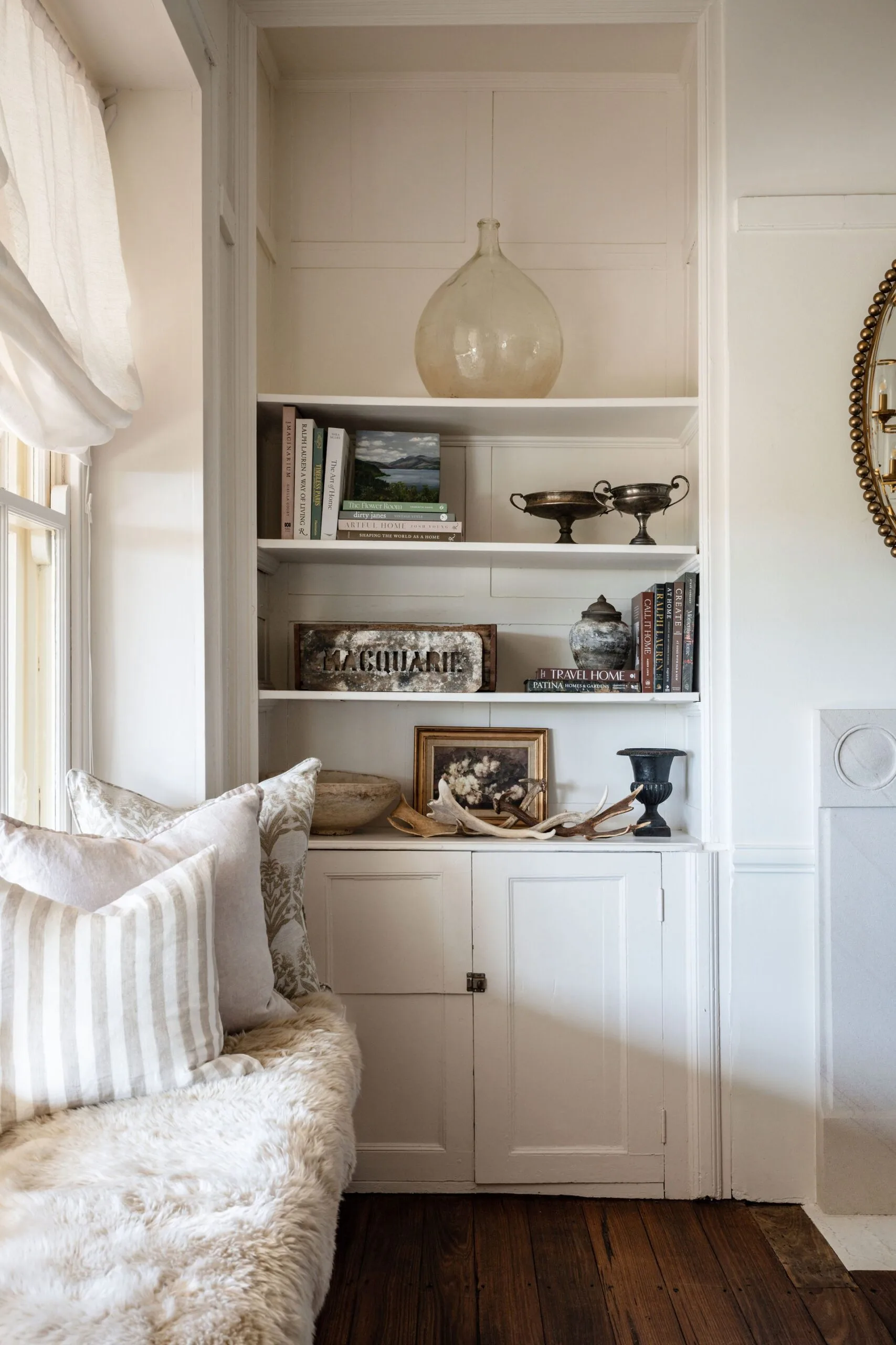 A window seat and shelving unit in a white dining room