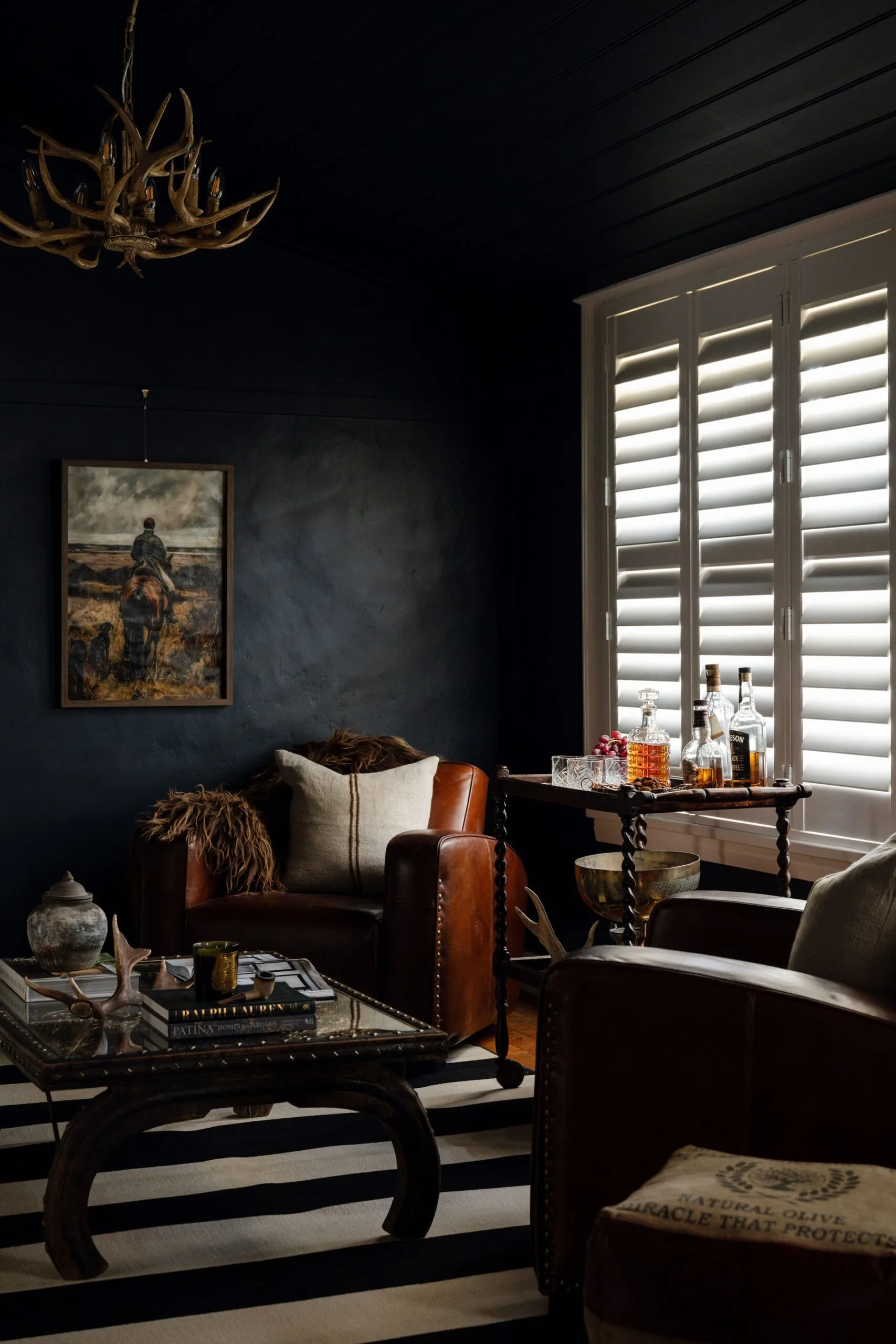 A dark, moody whiskey bar with leather armchairs