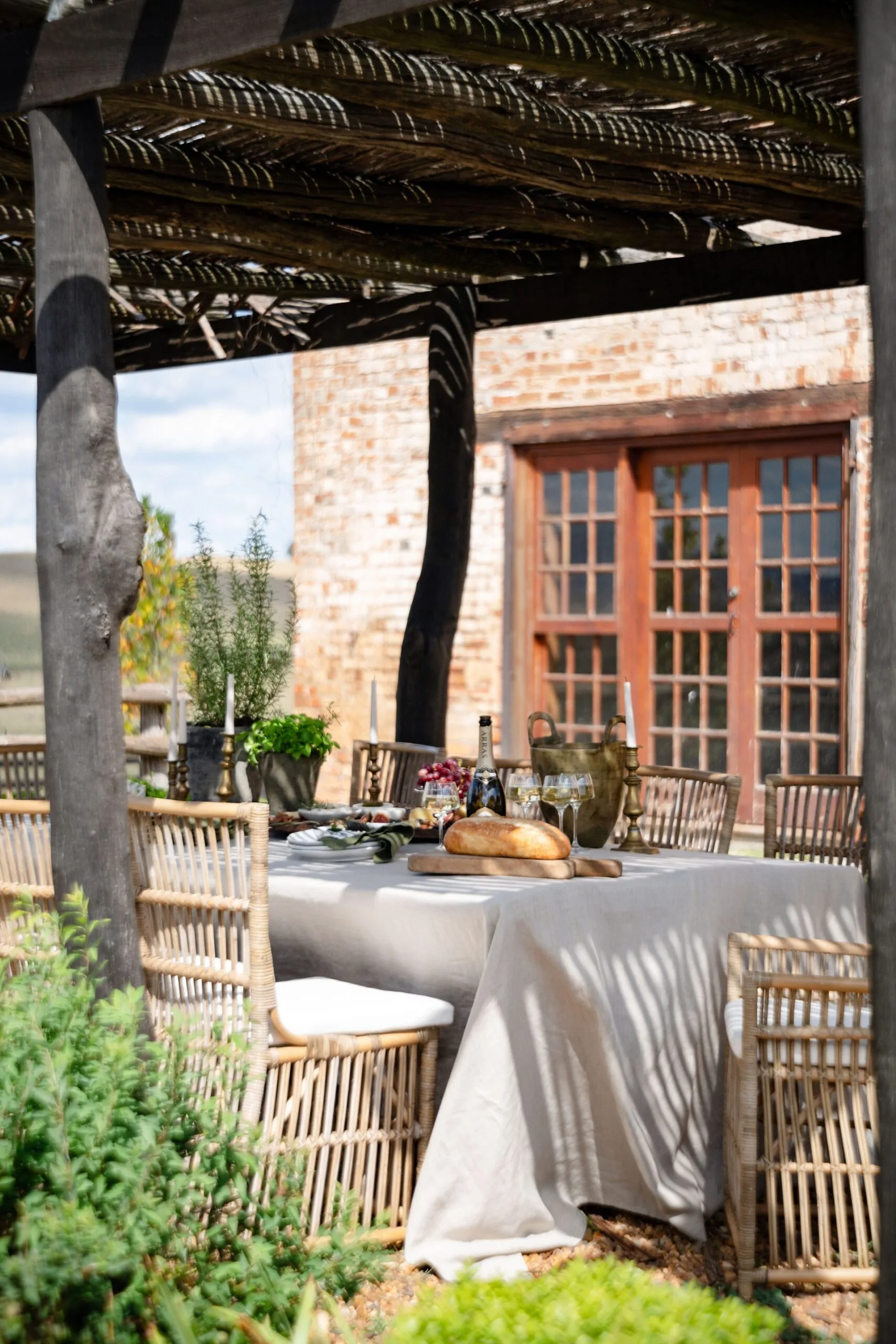 An outdoor entertainment area with a table topped with snacks and champagne
