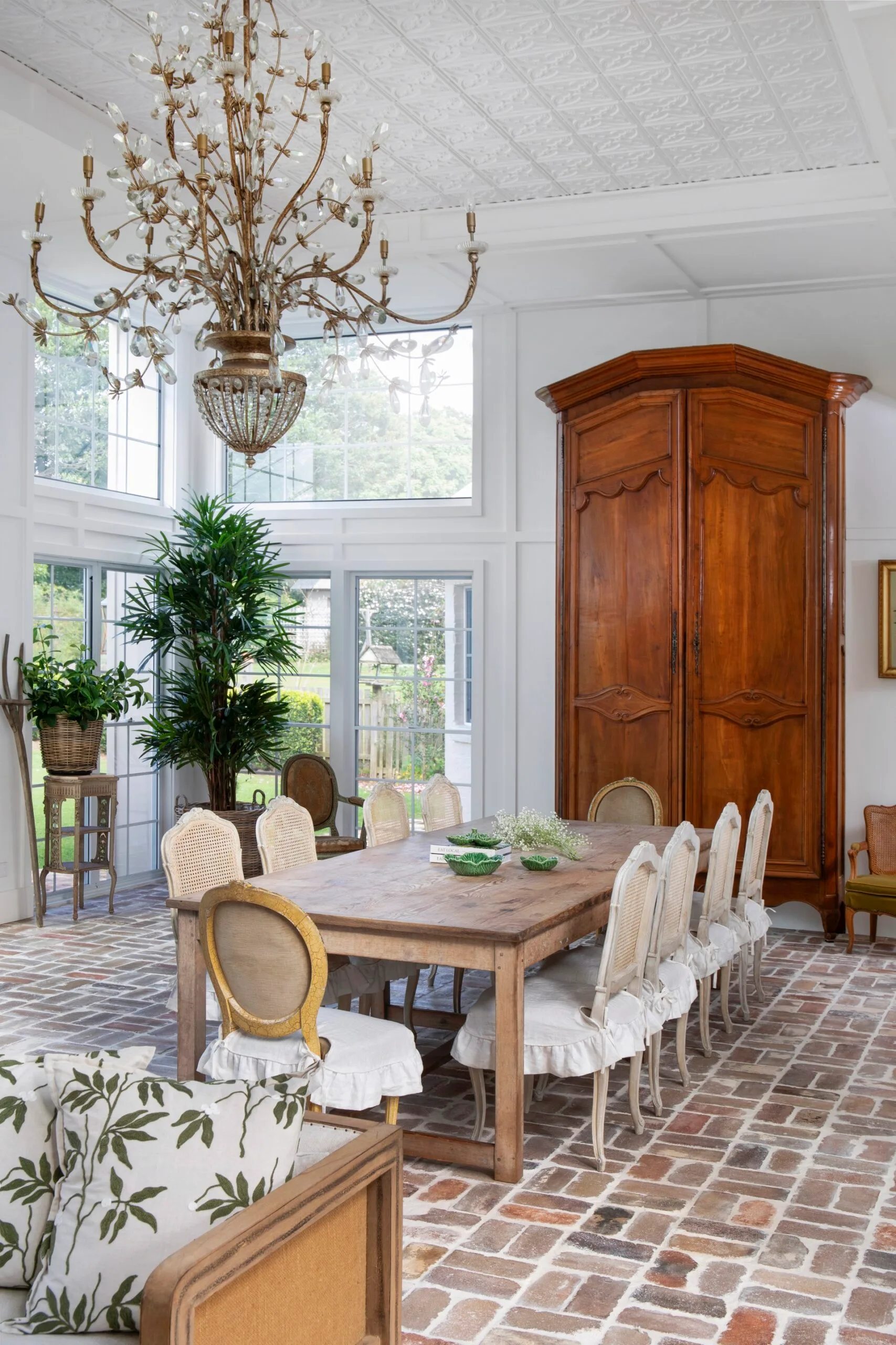 Dining and sunroom with an antique French library and chandelier