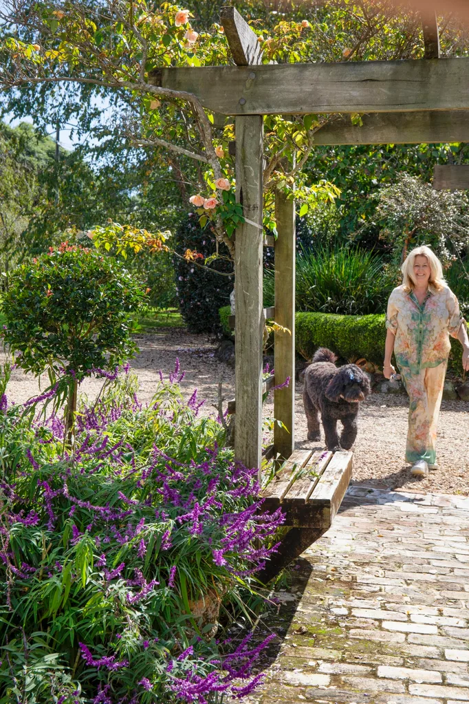 Mt Tamborine garden with an arbor featuring a woman and her poodle-cross dog