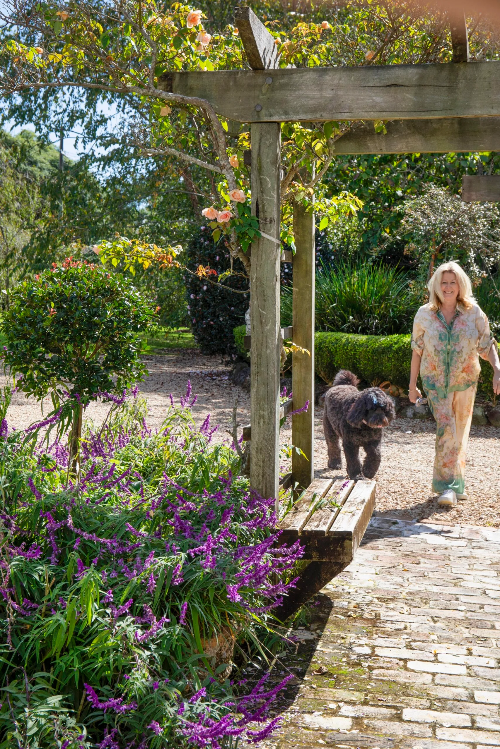 Mt Tamborine garden with an arbor featuring a woman and her poodle-cross dog