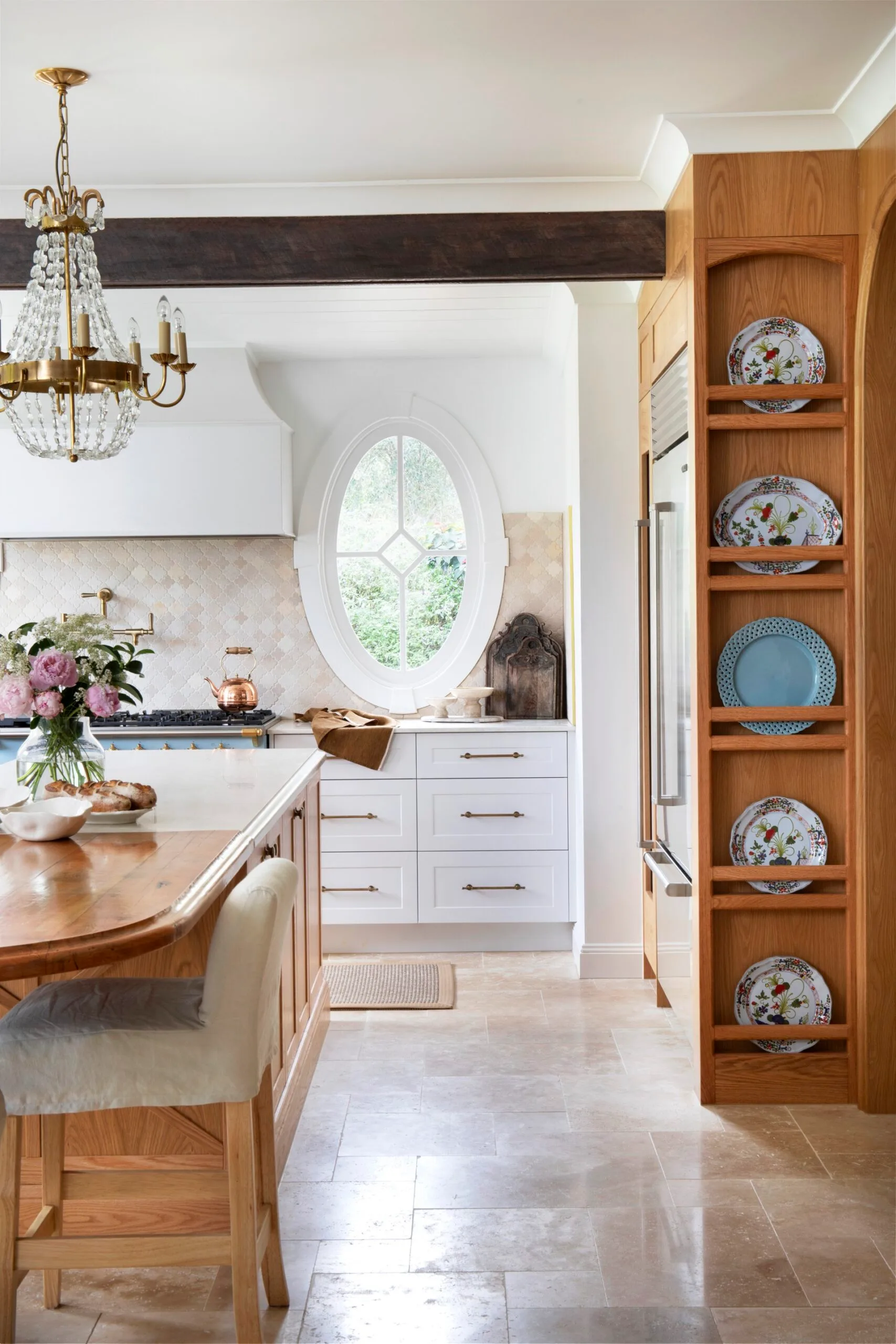 Farmhouse kitchen featuring display plates, an oval window, and a chandelier