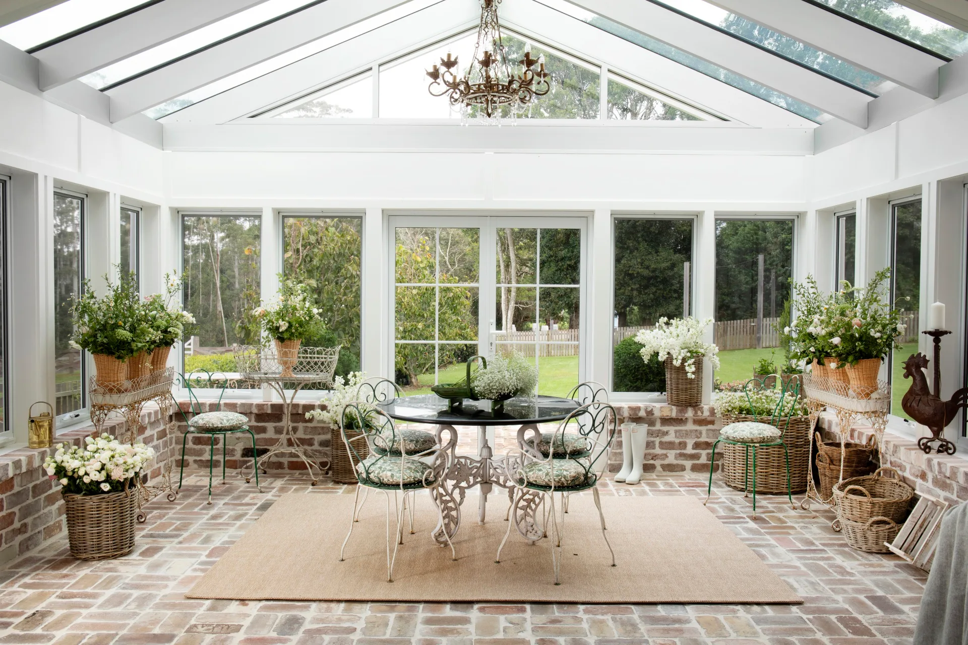 A sunroom with outdoor furniture and pot plants