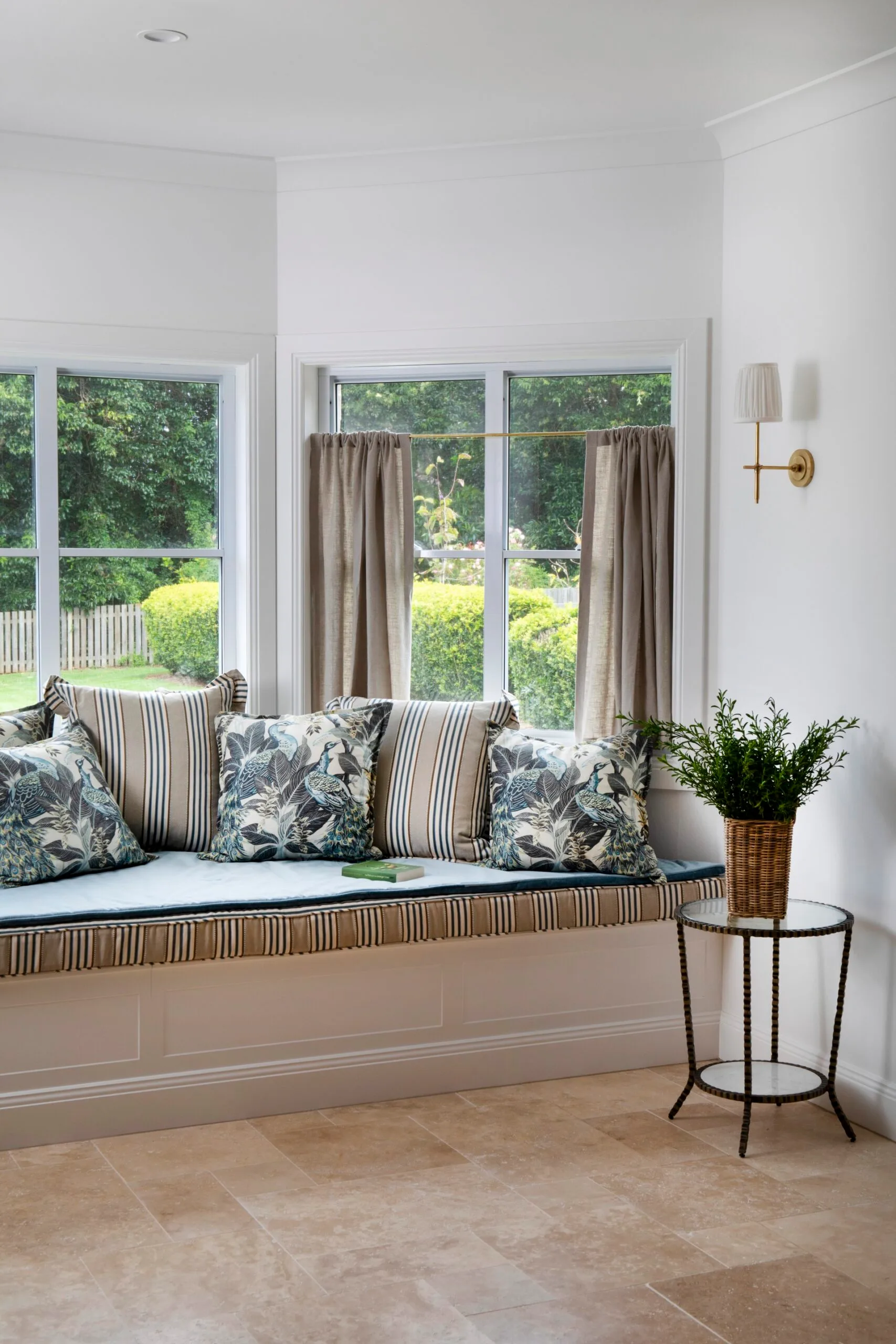 A window seat with cushions overlooking a garden view