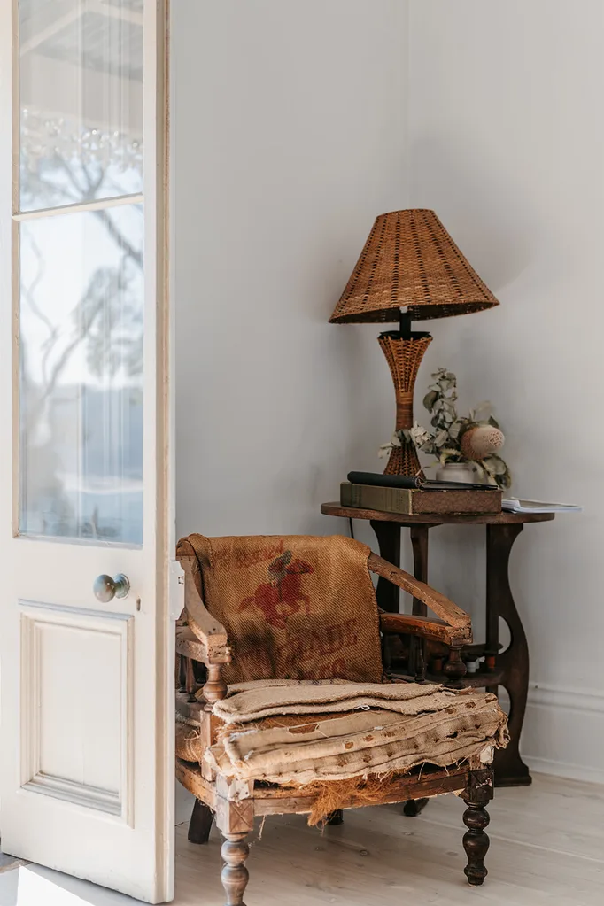 A vignette of an antique chair and side table