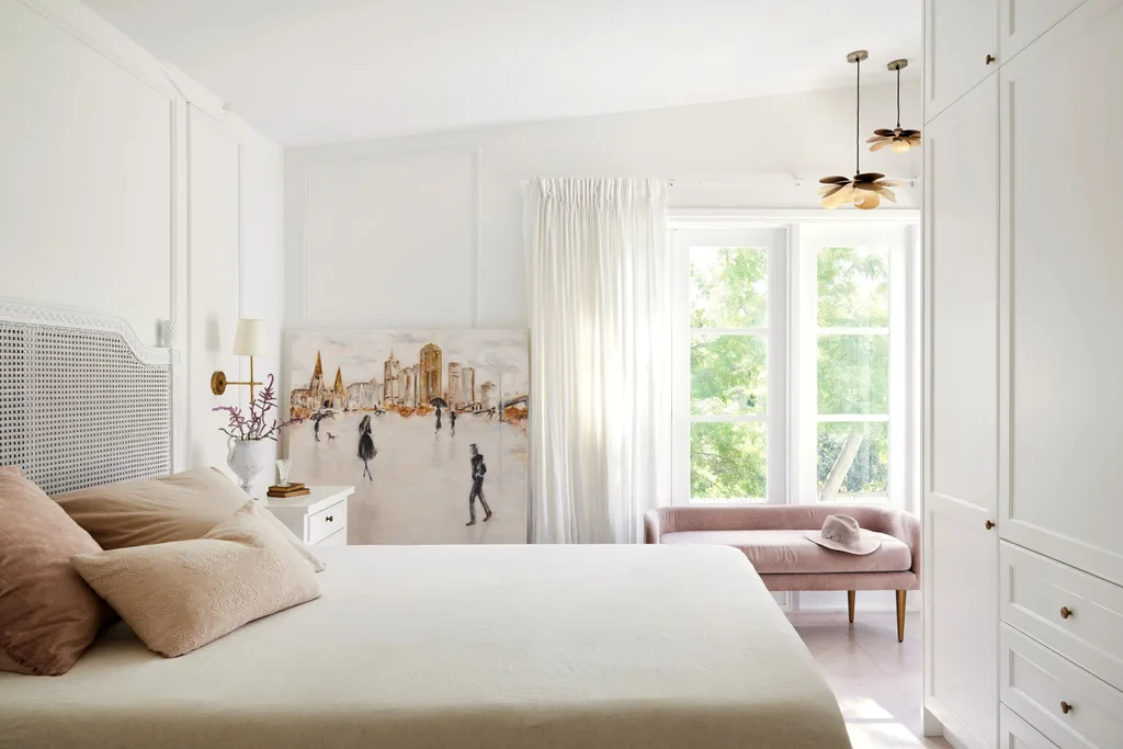 White bedroom featuring beige cushions, a pink daybed, and a rattan bedhead.