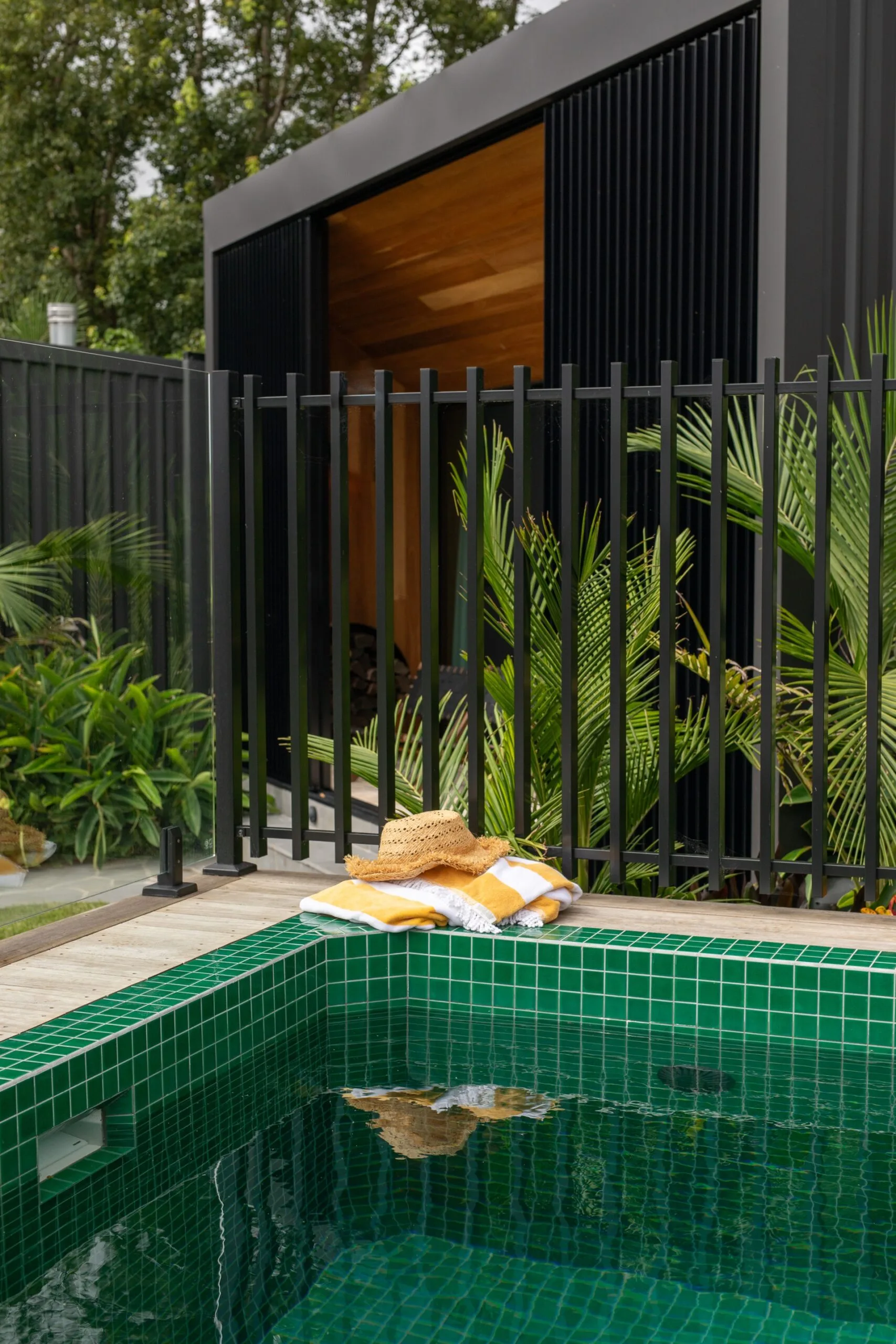 A mosaic-tiled swimming pool beside a modern villa